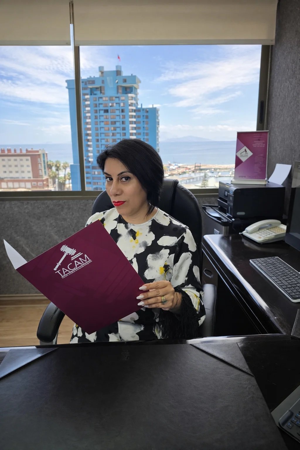 Sara Tapia González revisando una carpeta en las oficinas de TACAM